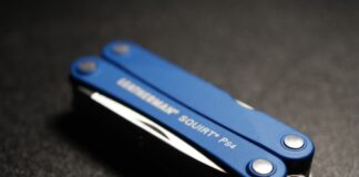 Multitool to jeden z podstawowych przedmiotów w zestawie survivalowym. na zdjęciu poręczny multitool Laethermana w kolorze niebieskim, złożony, leżący na czarnym stole.